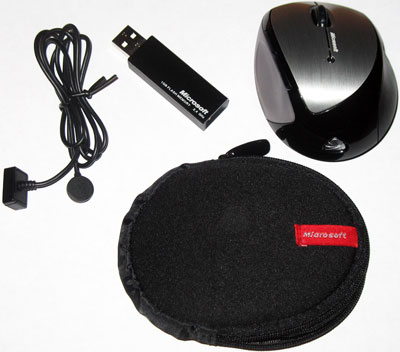 The complete Memory Mouse ensemble: mouse, wireless receiver, charging cable, and carrying case.